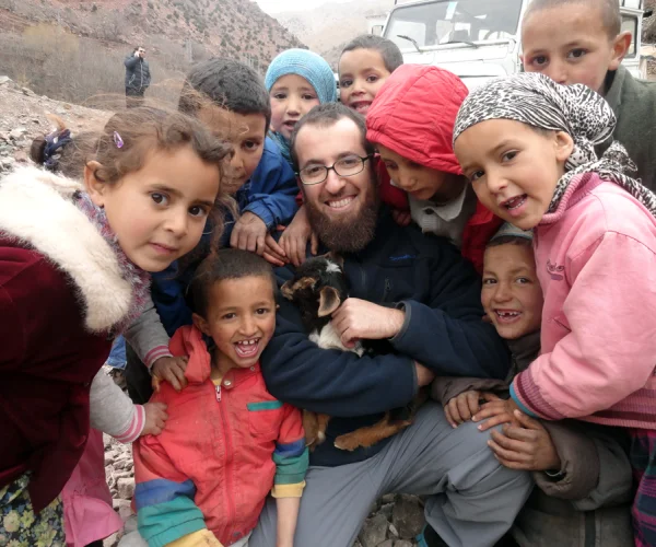 Holding a goat surrounded by kids