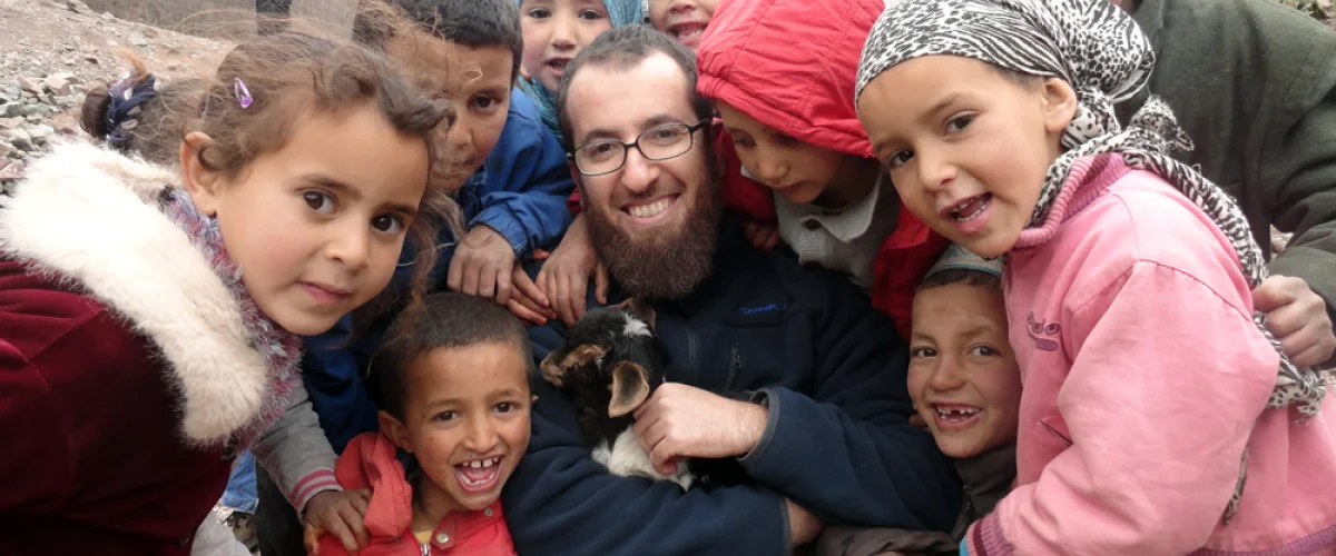 Holding a goat surrounded by kids