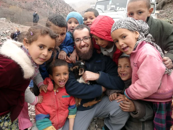 Holding a goat surrounded by kids
